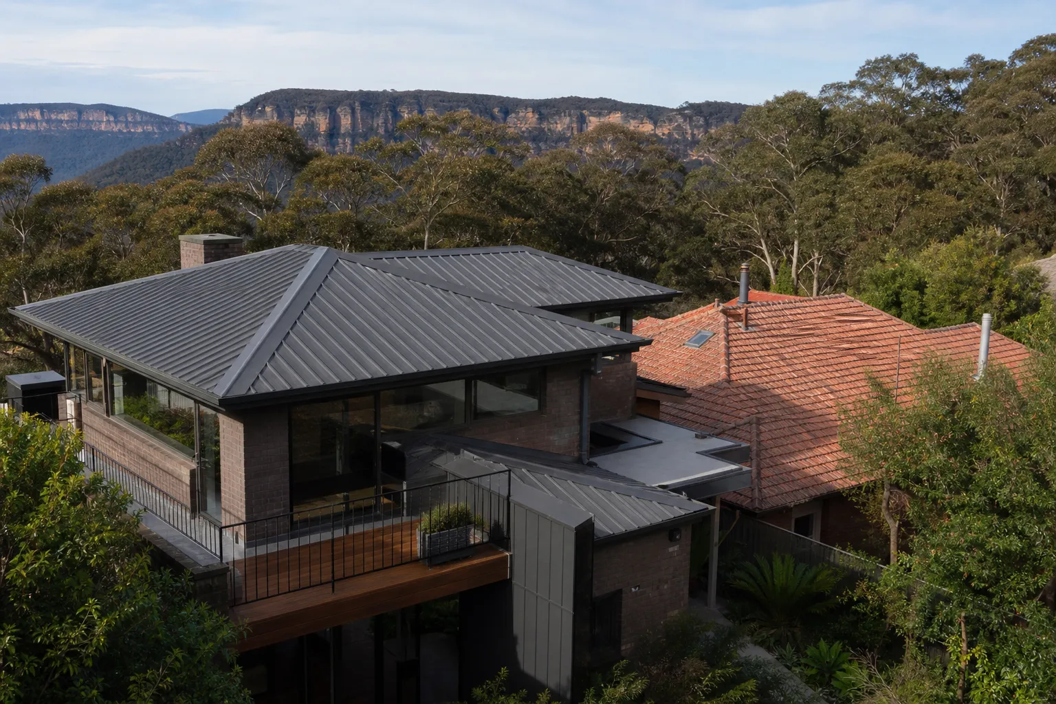 A Colorbond metal roof and a tiled roof side by side on neighbouring Blue Mountains homes