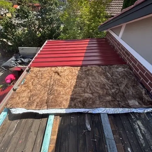 Colorbond sheets going down over new insulation — roofing work in Springwood, Blue Mountains NSW