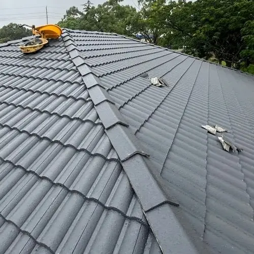 Tile roof in progress with worker visible — ridge capping and repointing work, Blue Mountains