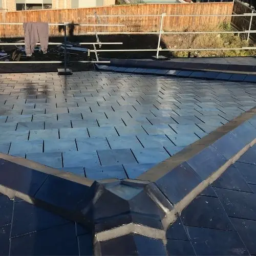 Dark low-pitch roof surface showing valleys and lead flashing detail — Blue Mountains roof inspection